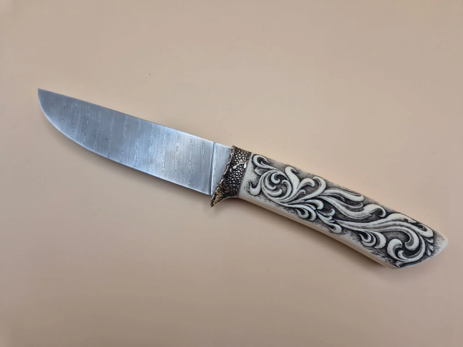 Hand-forged hunting knife with Damasteel blade and engraved ivory handle
